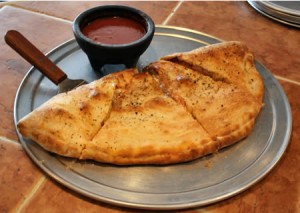 La pizza calzone se suele servir con un poco de salsa de tomate por encima y aveces algo de queso mozzarella. pizza calzone